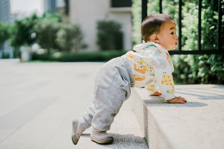 เด็กชายกำลังพยายามปีนขึ้นบันไดหินด้วยตัวเอง