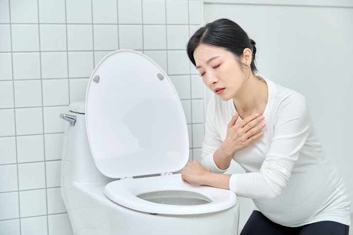 คุณแม่ทำท่าทางคลื่นไส้ในห้องน้ำ