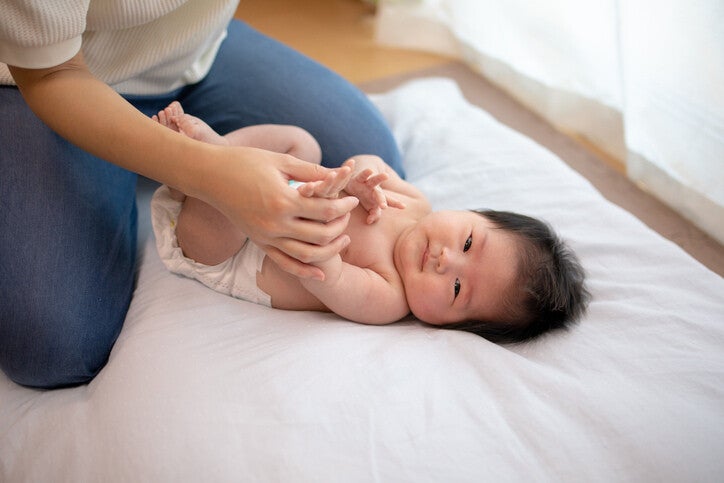 คุณแม่กำลังเปลี่ยนผ้าอ้อมให้ทารกในห้องนั่งเล่น