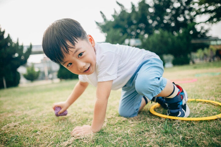 เด็กผู้ชายออกกำลังกายกลางแจ้งบนสนามหญ้า