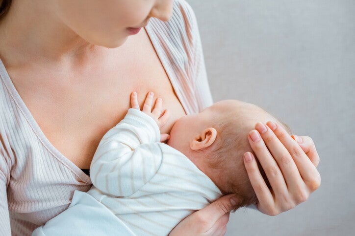 แม่ประคองทารกให้นมลูก