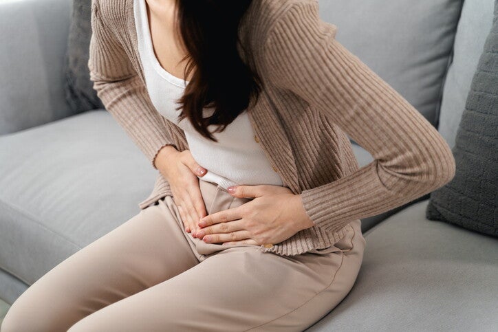 ผู้หญิงทำท่ากุมท้อง