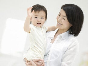 คุณแม่ยิ้มอย่างมีความสุขขณะกำลังอุ้มลูกน้อย