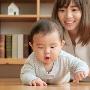 baby crawling in front of mom