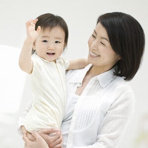 คุณแม่ยิ้มอย่างมีความสุขขณะกำลังอุ้มลูกน้อย