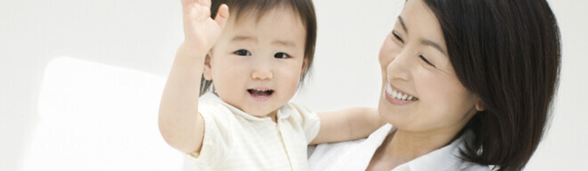 คุณแม่ยิ้มอย่างมีความสุขขณะกำลังอุ้มลูกน้อย